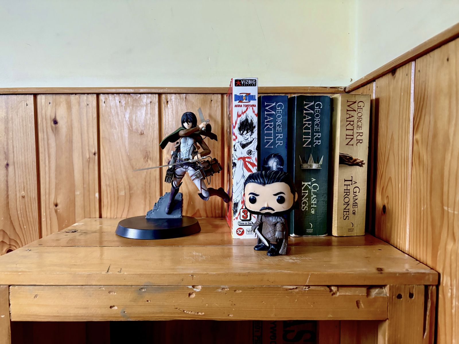 Wooden shelf with figurines and books at Misfits