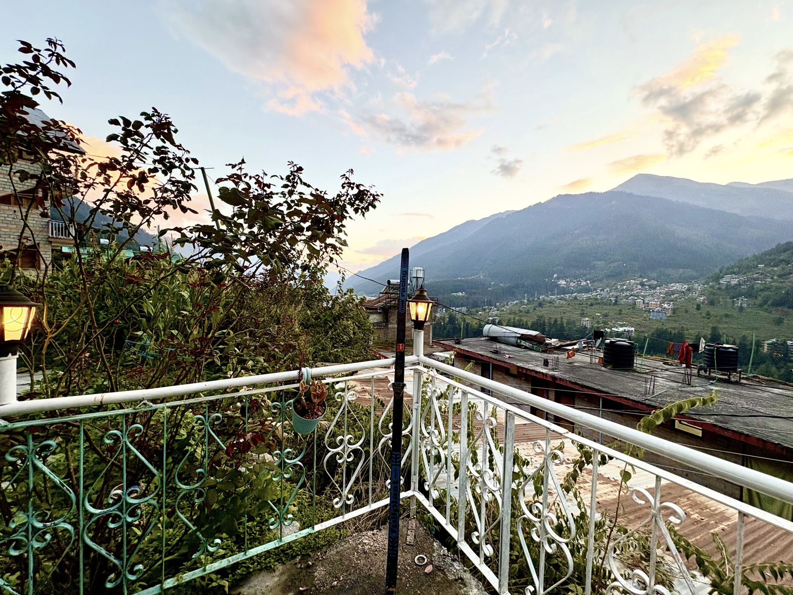 Terrace railing with lamps at sunset overlooking the Manali valley